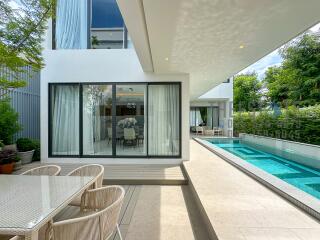 Modern outdoor living space with a swimming pool and dining area