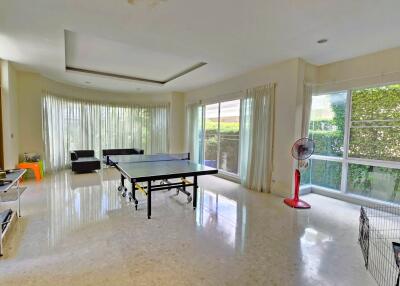 Spacious living area with large windows and table tennis setup