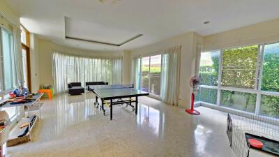 Spacious living area with large windows and table tennis setup