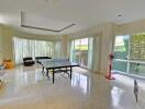 Spacious living area with large windows and table tennis setup