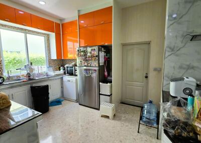 Modern kitchen with bright orange cabinets and large window