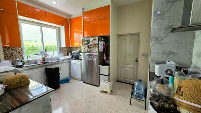 Modern kitchen with bright orange cabinets and large window