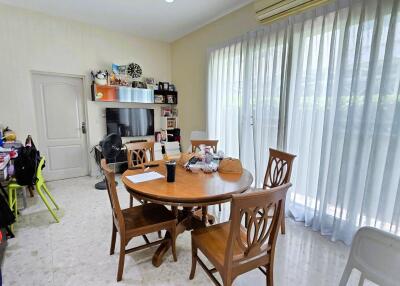 Dining room with wooden table, chairs, and large window