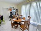 Dining room with wooden table, chairs, and large window