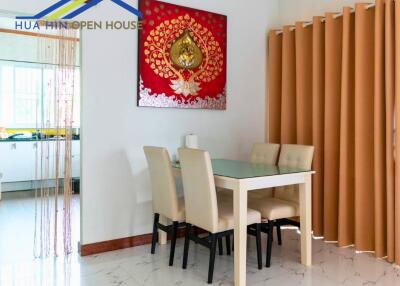 Dining area with table, chairs, and draped windows