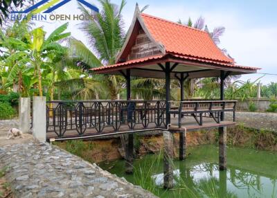 Traditional Thai-style pavilion over a pond