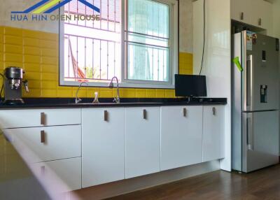 Modern kitchen with white cabinets and yellow backsplash