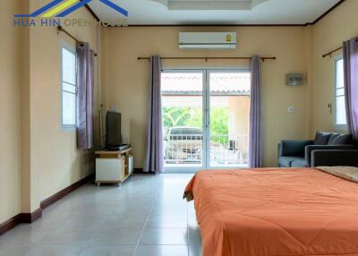 Spacious bedroom with sliding glass doors and attached balcony.