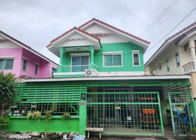 Front view of a two-story residential building with a green façade