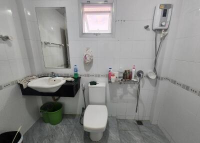 Modern bathroom with a wall-mounted sink, toilet, and shower