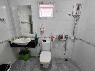 Modern bathroom with a wall-mounted sink, toilet, and shower