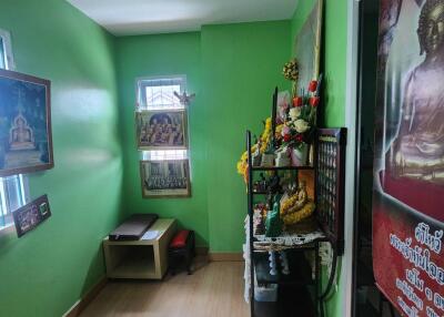 Small room with green walls and Buddhist decor