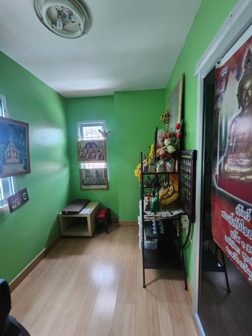 Small room with green walls and Buddhist decor