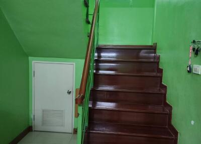 A wooden staircase with green walls