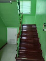 A wooden staircase with green walls