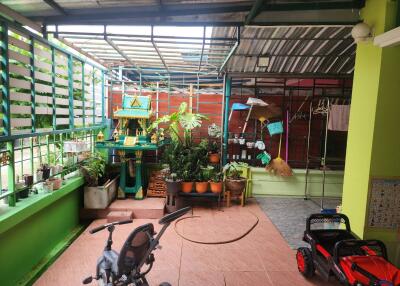 Covered outdoor living area with plants and children