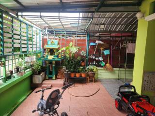 Covered outdoor living area with plants and children