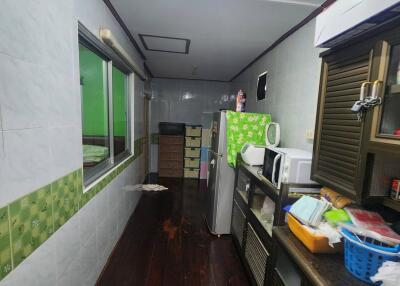 Narrow kitchen with wooden floor and multiple appliances