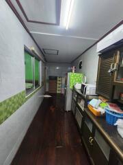 Narrow kitchen with wooden floor and multiple appliances