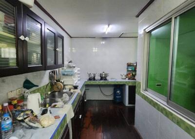 A spacious kitchen with dark wooden cabinets and modern appliances