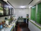 A spacious kitchen with dark wooden cabinets and modern appliances