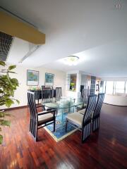 Spacious and modern dining area with a large glass table and stylish chairs