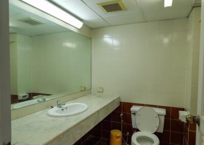 Bathroom with large mirror and tiled walls