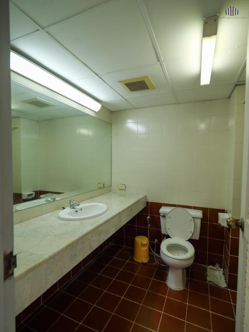 Bathroom with large mirror and tiled walls