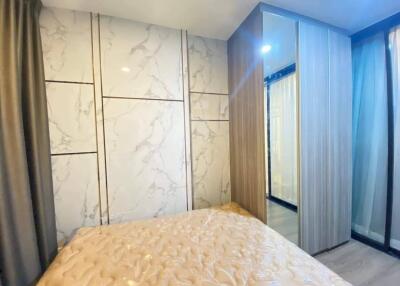 Modern bedroom with marble accent walls and fitted wardrobe