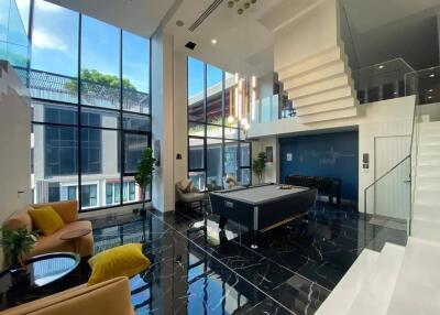 Spacious modern living area with high ceilings and pool table