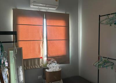 Small bedroom with air conditioner and storage items