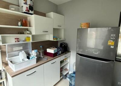 Modern kitchen with grey refrigerator and white cabinets