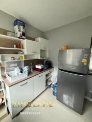 Modern kitchen with grey refrigerator and white cabinets