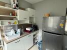 Modern kitchen with grey refrigerator and white cabinets