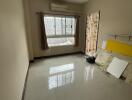 Empty bedroom with large window and air conditioning