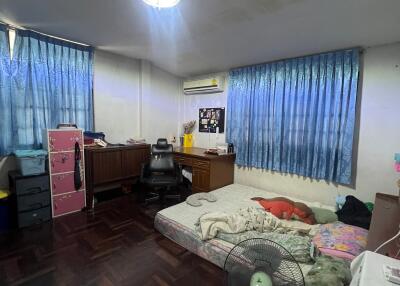 Bedroom with wooden floors, a double bed, and a freestanding fan