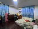 Bedroom with wooden floors, a double bed, and a freestanding fan