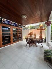 Covered patio area with wooden ceiling and glass doors