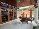 Covered patio area with wooden ceiling and glass doors