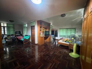 Spacious living area with beds, computer desk, and TV unit