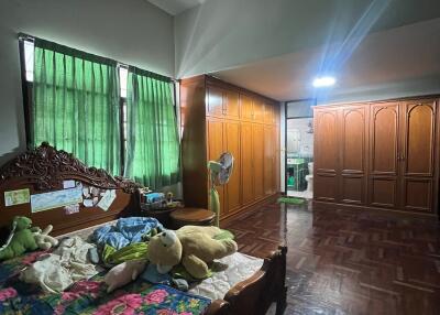 Spacious bedroom with wooden furniture and large windows