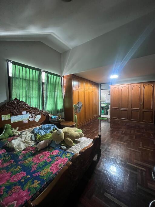 Spacious bedroom with wooden furniture and large windows