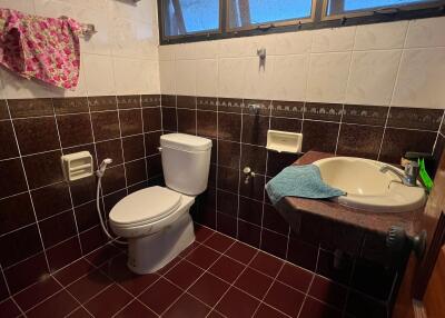 Bathroom with tiled walls and floor, and a small window