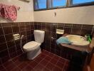 Bathroom with tiled walls and floor, and a small window