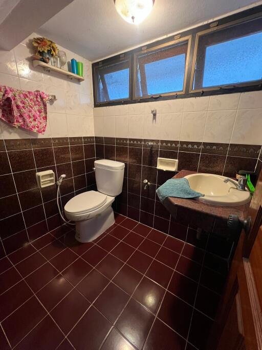 Bathroom with tiled walls and floor, and a small window