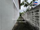 Pathway beside building with wall and vegetation