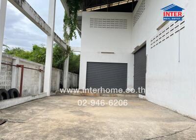 Exterior view of the property showing a spacious concrete area with roller doors