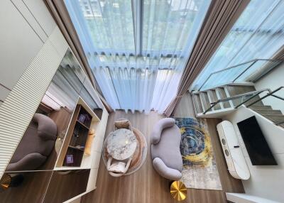 Modern living room with large floor-to-ceiling windows and a view of the outside.