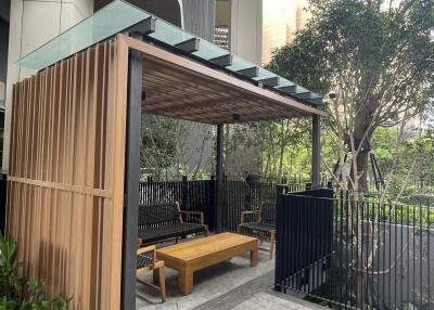 Modern outdoor seating area with wooden pergola and greenery