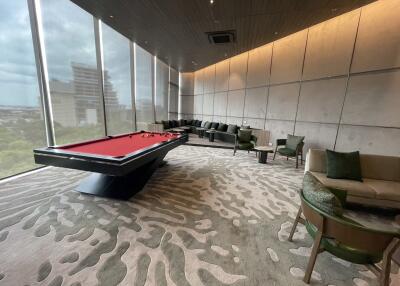 Modern lounge area with a pool table and large windows